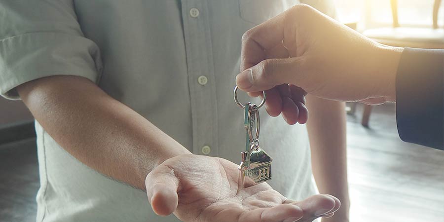 A landlord passing over keys to a tennant. 