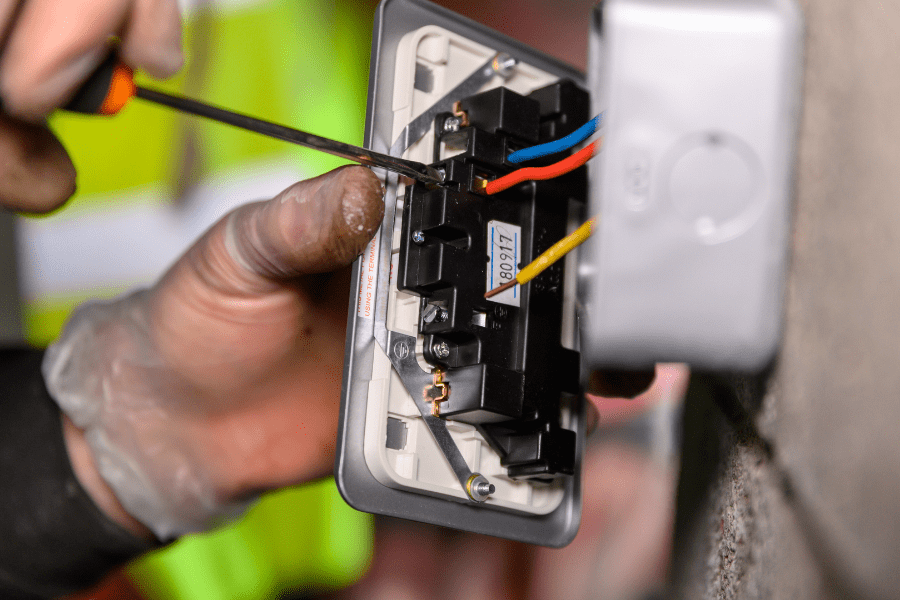 Image showing a plug socket with the wires being unscrewed from the terminal.