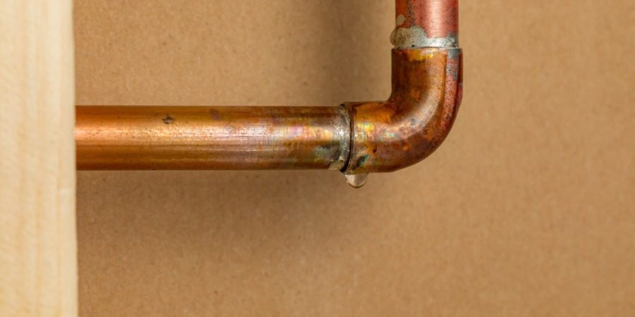A copper pipe suffering a slow leak at a join.