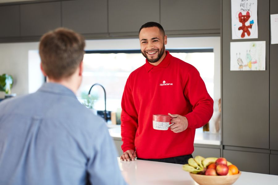 Engineer having a conversation in a customer's kitchen after repairing their boiler
